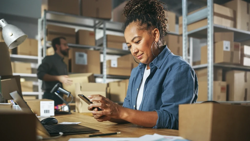 Worker scanning package barcode in warehouse.