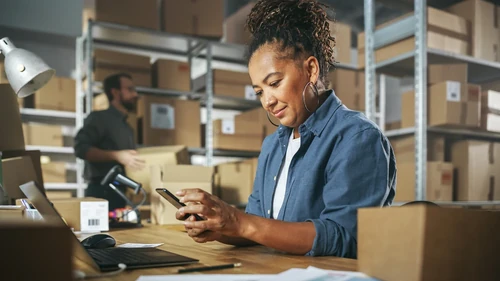Worker scanning package barcode in warehouse.